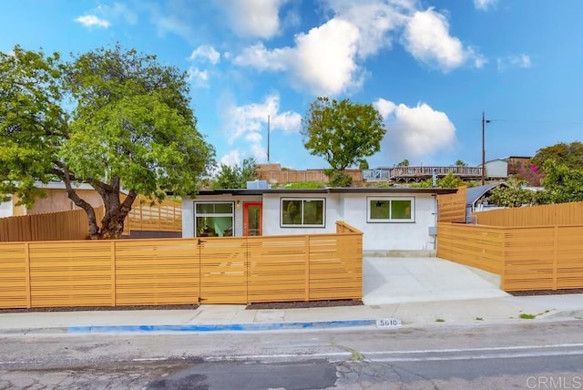 single story home featuring a fenced front yard and stucco siding