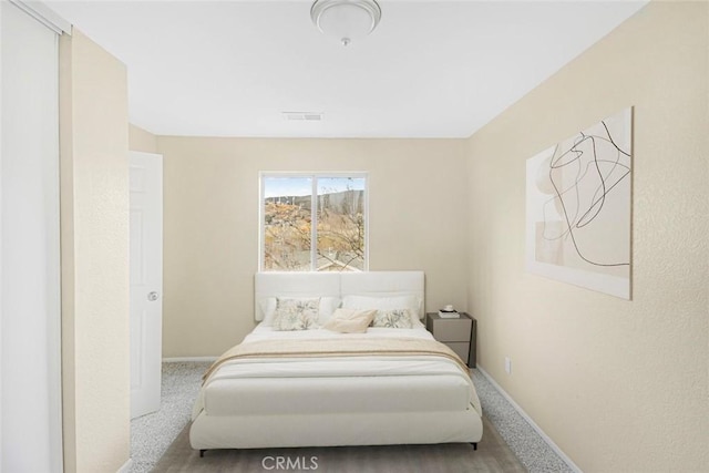 carpeted bedroom featuring visible vents and baseboards