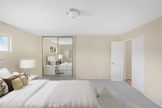 bedroom with carpet flooring, baseboards, and a closet