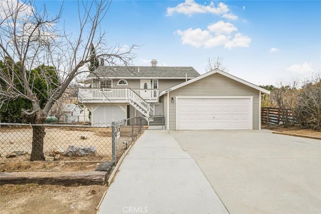 view of front of house featuring driveway, fence, an attached garage, a shingled roof, and stairs