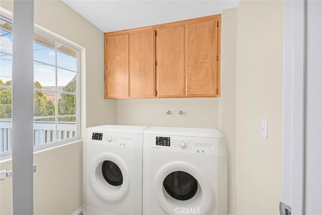 washroom with cabinet space and washer and clothes dryer