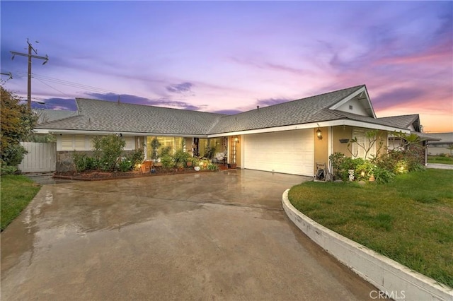 ranch-style home featuring an attached garage, driveway, a lawn, and stucco siding