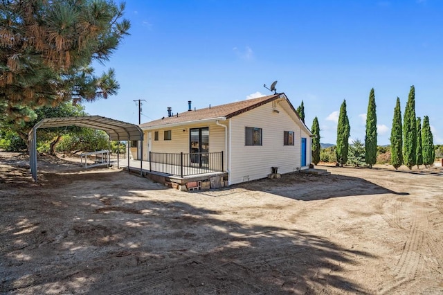 back of house with crawl space, dirt driveway, and a detached carport