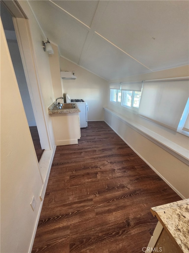 hallway with lofted ceiling, dark wood-style floors, baseboards, and washing machine and clothes dryer