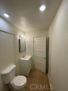 bathroom featuring recessed lighting, toilet, vanity, and tile patterned flooring