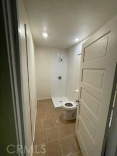 full bathroom featuring a stall shower and toilet