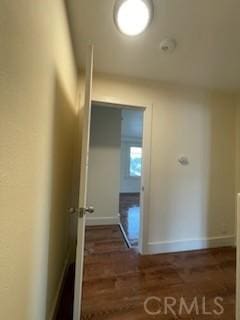 hallway featuring wood finished floors and baseboards