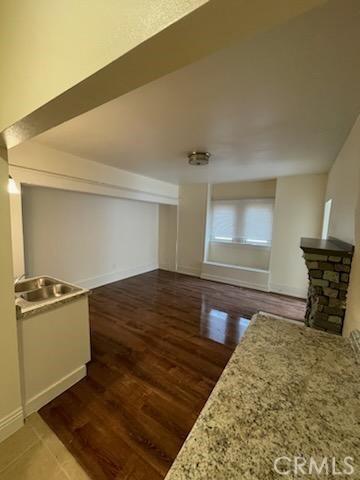 interior space with a fireplace, wood finished floors, and baseboards