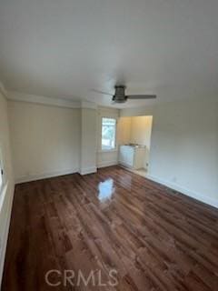 interior space with ceiling fan, baseboards, wood finished floors, and crown molding