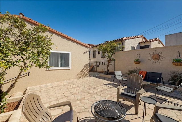 view of patio with fence and a fire pit