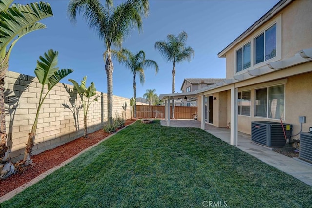 view of yard with a fenced backyard, a patio, and central AC