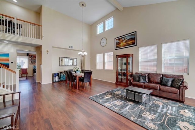 living area with visible vents, a chandelier, beamed ceiling, stairway, and wood finished floors