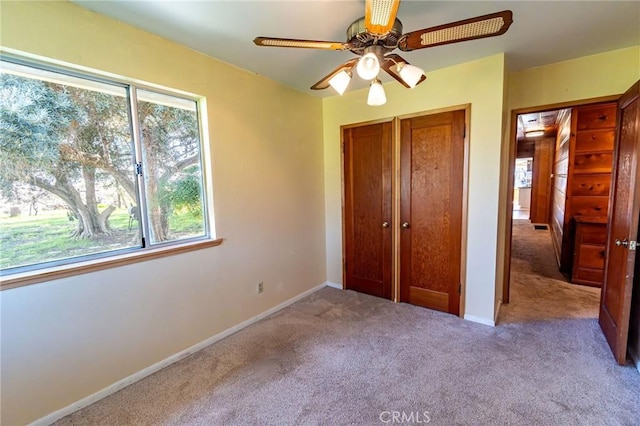 unfurnished bedroom with a closet, baseboards, carpet flooring, and multiple windows