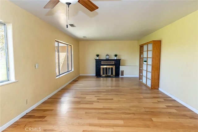 4760 County Rd 99 W, Orland, CA 96963 - unfurnished living room with healthy amount of natural light, a fireplace, ceiling fan, and light wood-style floors