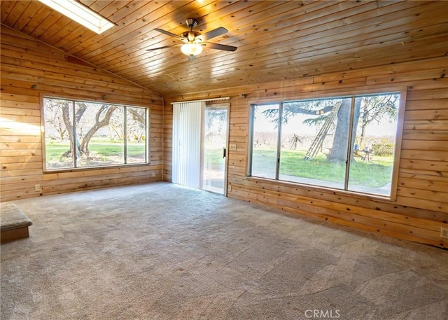 unfurnished living room featuring wood walls, wood ceiling, lofted ceiling with skylight, and carpet