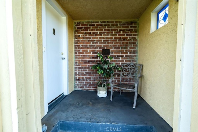 entrance to property with brick siding and stucco siding