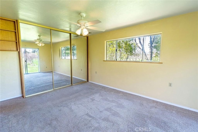 unfurnished bedroom featuring multiple windows, carpet, and baseboards