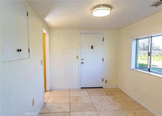 interior space featuring light tile patterned floors and baseboards