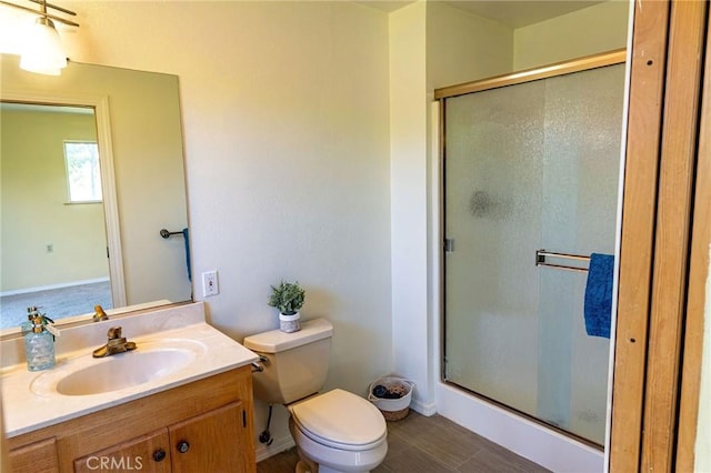 full bath featuring a stall shower, vanity, and toilet