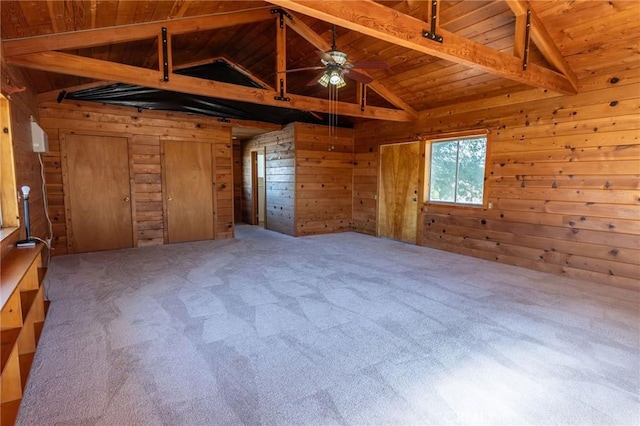 interior space with vaulted ceiling with beams, wood walls, wood ceiling, and a ceiling fan