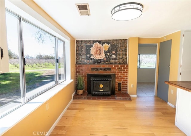 unfurnished living room with light wood-style floors, baseboards, and visible vents