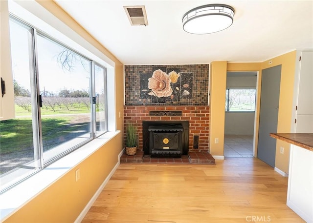 4760 County Rd 99 W, Orland, CA 96963 - unfurnished living room featuring light wood-type flooring, baseboards, and a wood stove
