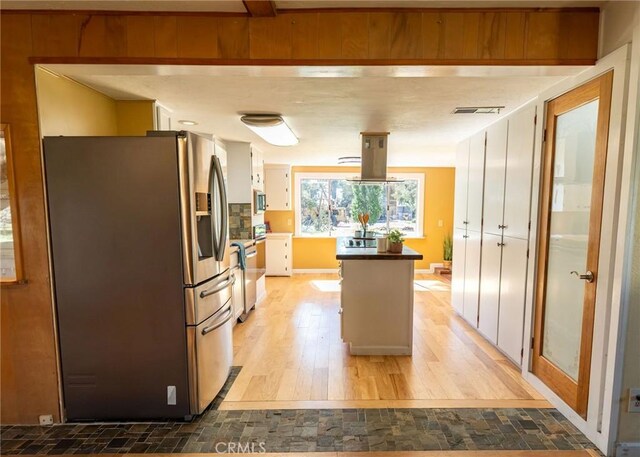 kitchen featuring visible vents, a kitchen island, appliances with stainless steel finishes, island exhaust hood, and light wood-type flooring