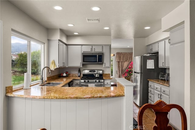 kitchen featuring visible vents, a sink, recessed lighting, stainless steel appliances, and a peninsula