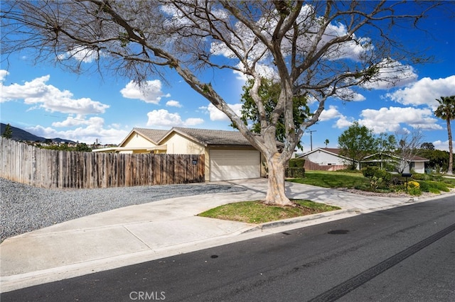 view of front of home featuring fence, a garage, and driveway