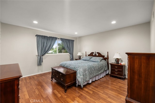 bedroom with recessed lighting, wood finished floors, and baseboards