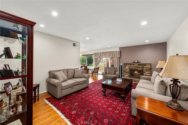 living room featuring visible vents, recessed lighting, a stone fireplace, and wood finished floors