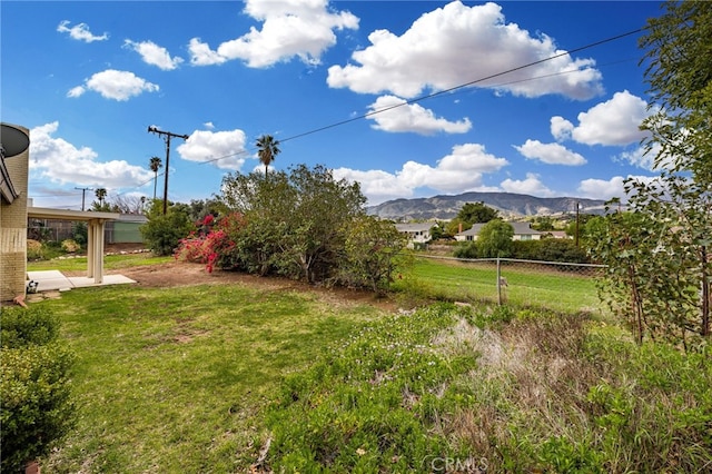 view of yard featuring fence and a mountain view