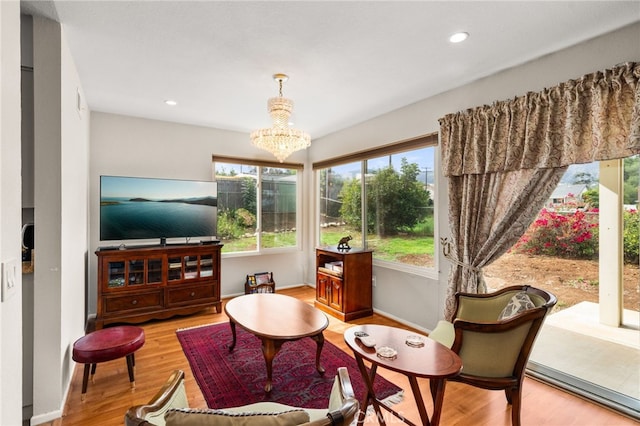 living area featuring an inviting chandelier, recessed lighting, wood finished floors, and baseboards