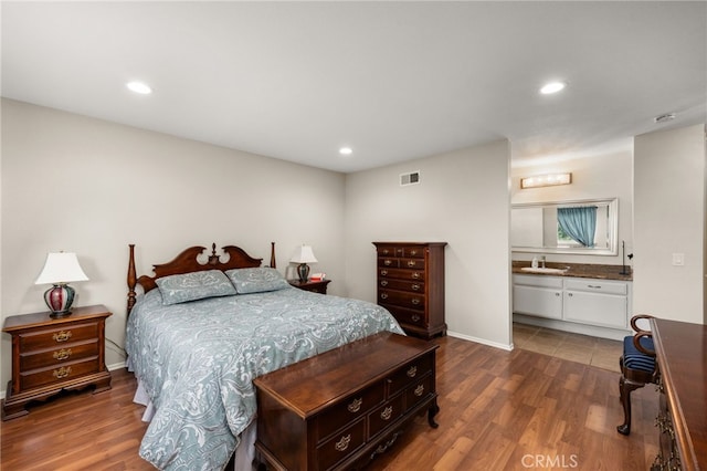 bedroom with a sink, baseboards, wood finished floors, and recessed lighting