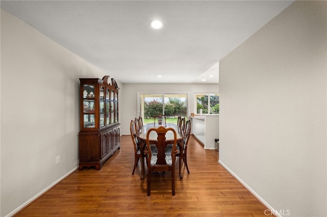 dining room with recessed lighting, baseboards, and light wood-style flooring