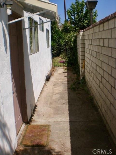 view of side of home with fence and stucco siding