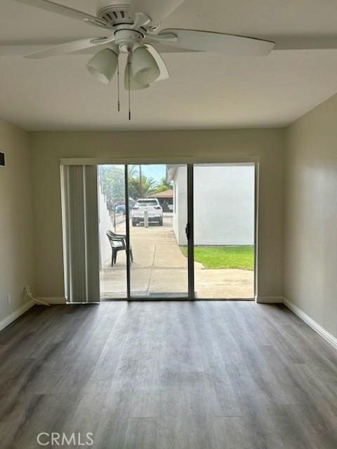 unfurnished room featuring ceiling fan, baseboards, and wood finished floors