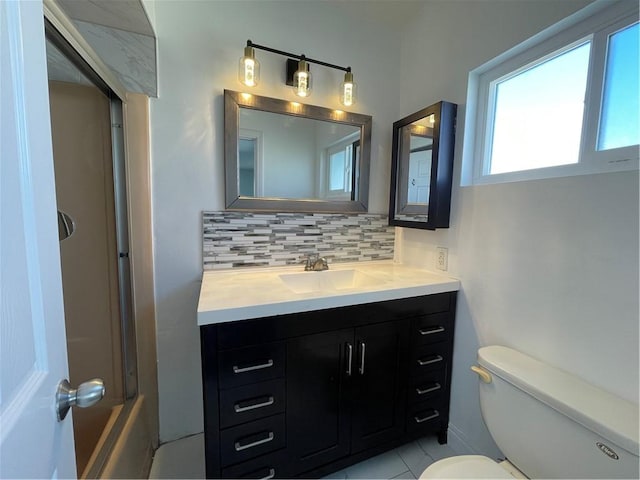 bathroom featuring tasteful backsplash, vanity, and toilet