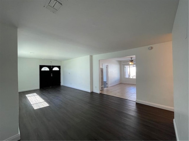 unfurnished living room featuring ceiling fan, wood finished floors, visible vents, and baseboards