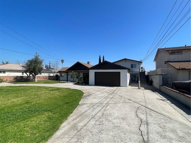 view of front of house featuring an attached garage, concrete driveway, and a front yard