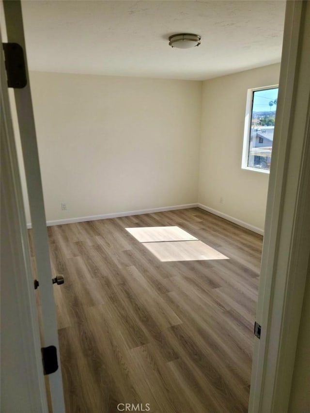 empty room with wood finished floors and baseboards