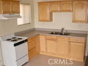 kitchen featuring light brown cabinetry, a sink, white range with electric stovetop, and under cabinet range hood