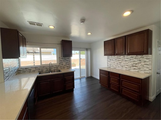 kitchen with light countertops, dark wood finished floors, a sink, and visible vents