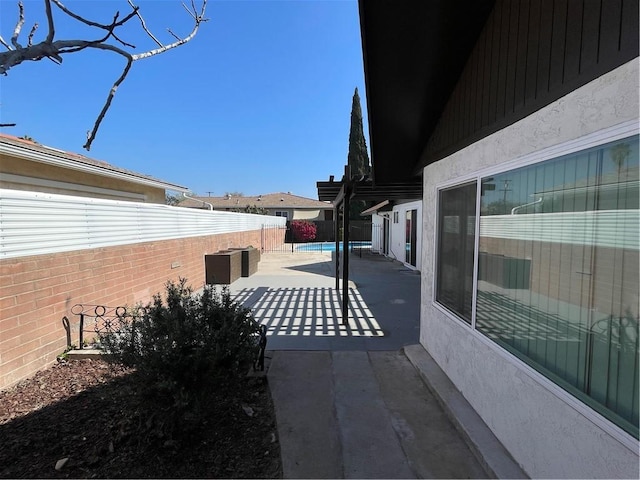 view of side of home featuring a patio area and a fenced backyard