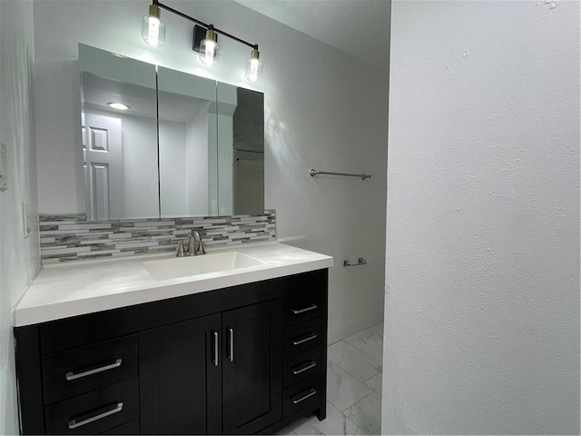 bathroom featuring marble finish floor, tasteful backsplash, and vanity