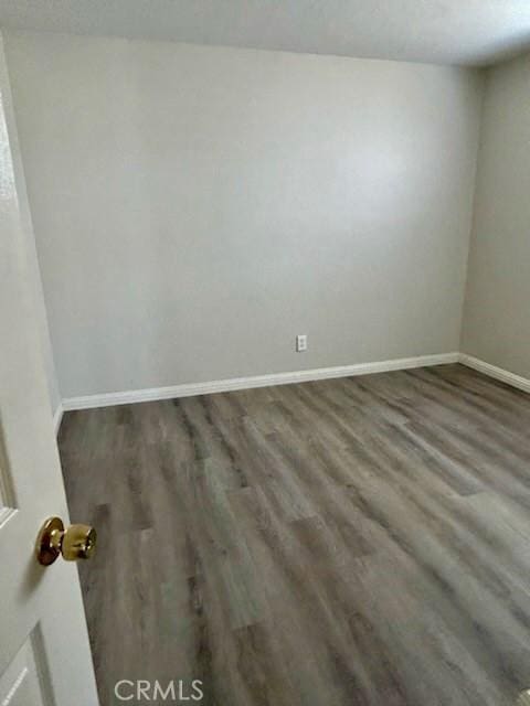 unfurnished room featuring baseboards and wood finished floors