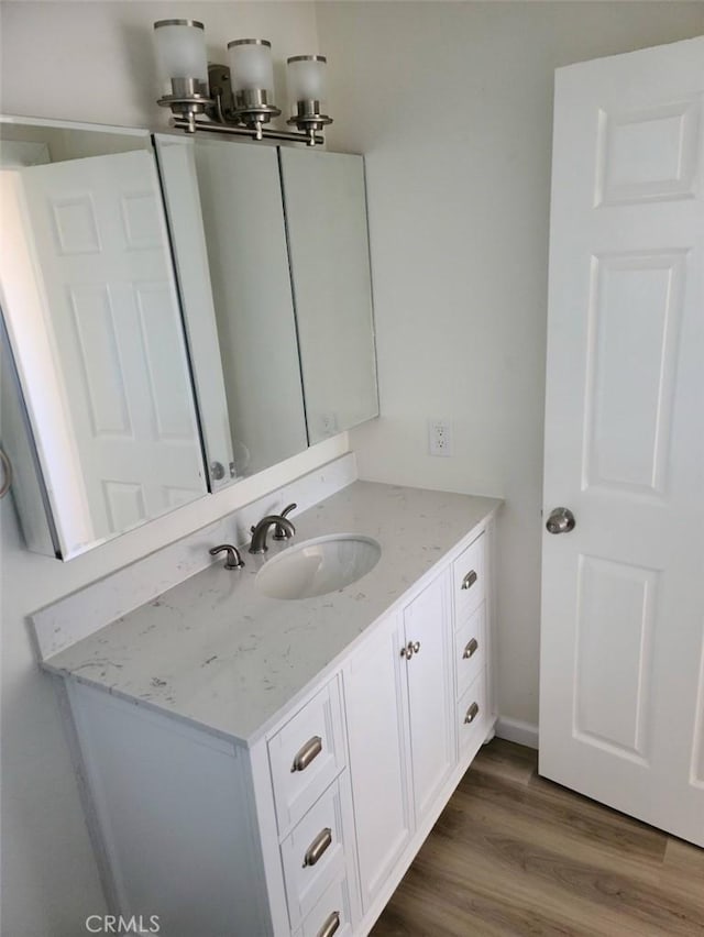 bathroom with wood finished floors and vanity