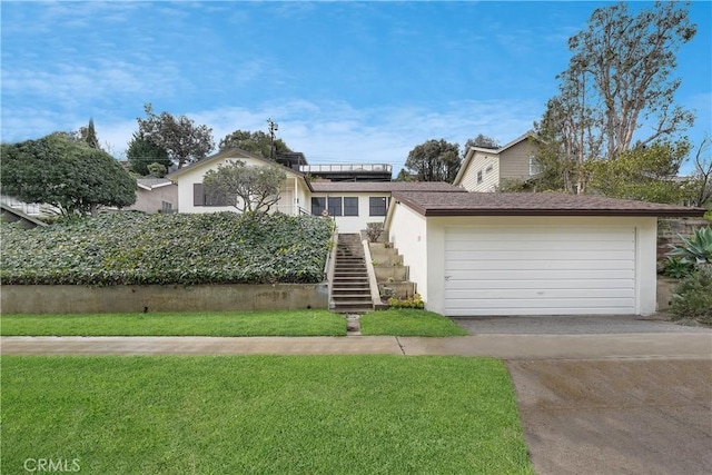 view of front facade with stairway, driveway, solar panels, and a front yard