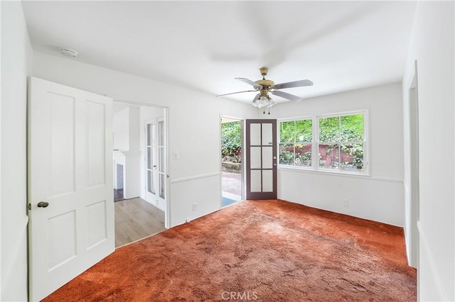 carpeted spare room featuring a ceiling fan and french doors