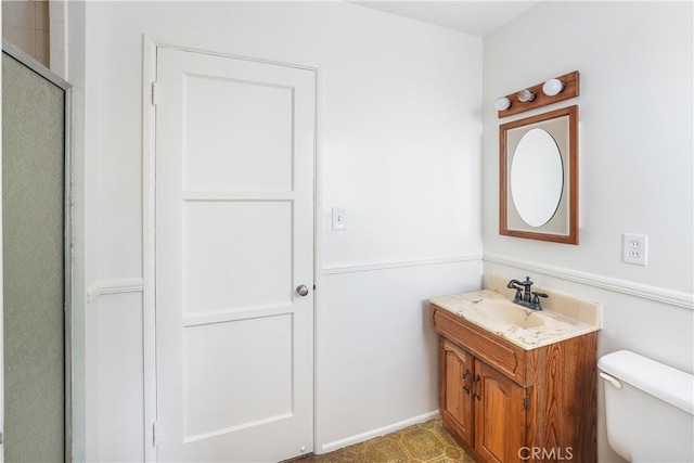 bathroom with a shower with door, toilet, and vanity